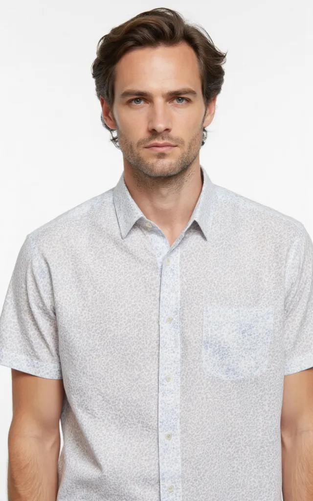 A French model wearing a Mottled pattern   printed shirt, against a white background, in a front   facing bust portrait